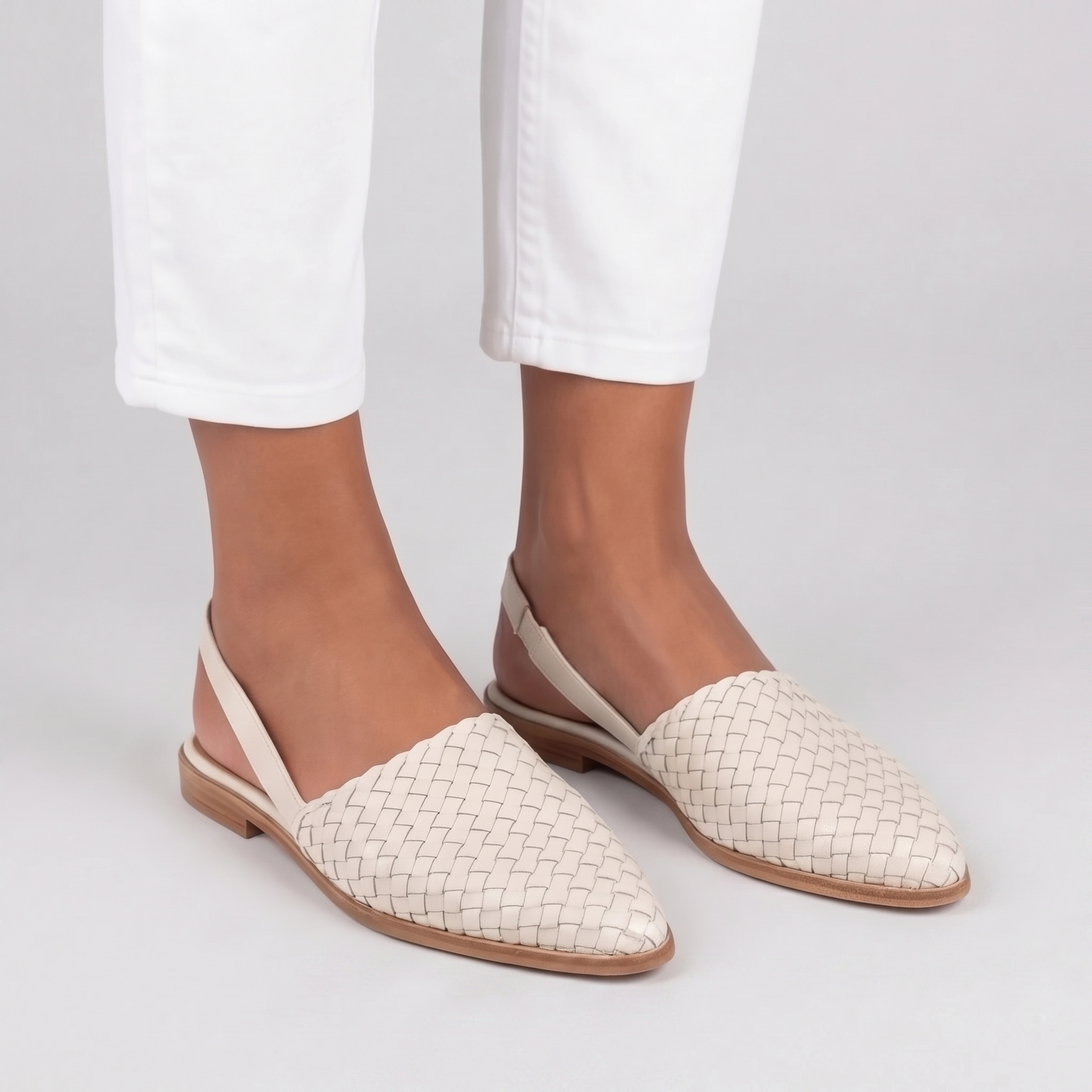 Sandales plates tressées femme blanches portées bride arrière et pantalon blanc