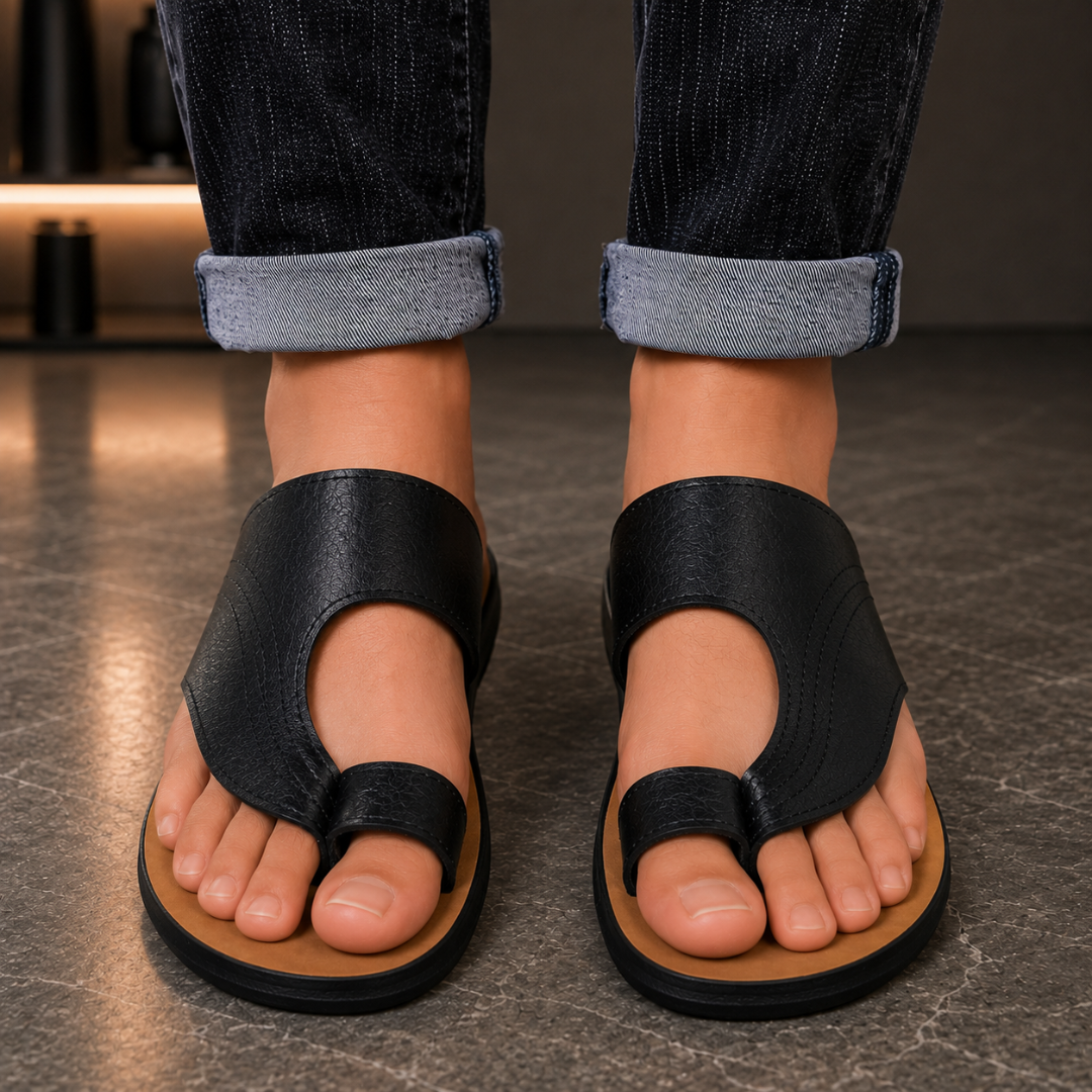 Sandales homme noires à bride d'orteil vues de dessus sur pavés