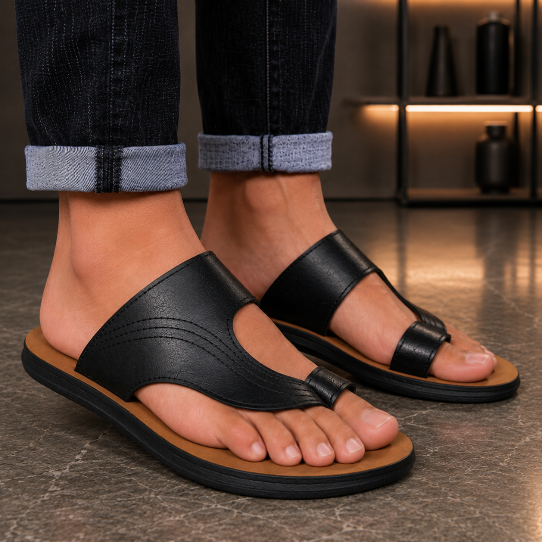 Paire de sandales homme noires à bout ouvert portées avec jean