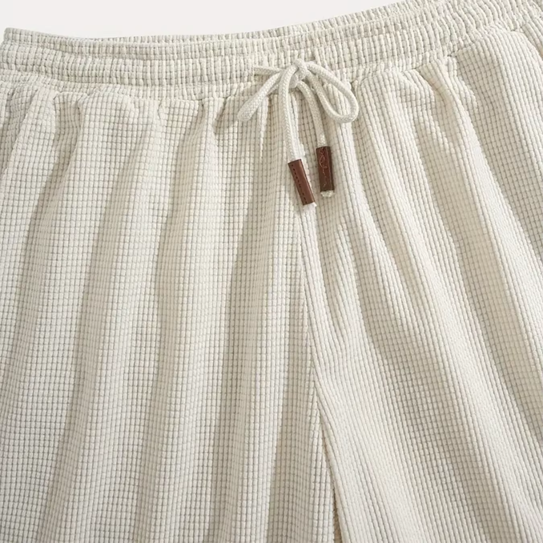Gros plan de la taille élastique beige avec cordon noué et embouts marron