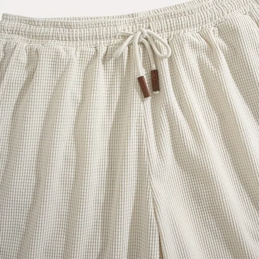 Gros plan de la taille élastique beige avec cordon noué et embouts marron