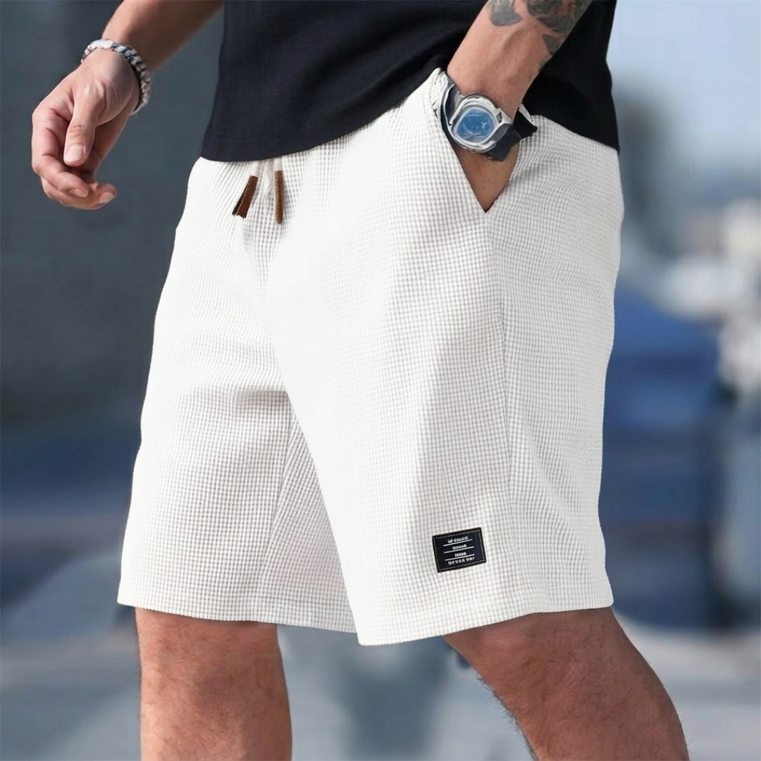 Short homme casual blanc porté avec cordon de serrage et étiquette latérale