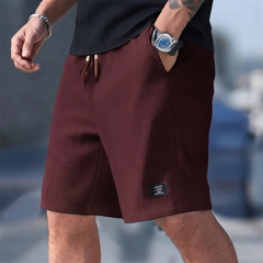 Short homme casual bordeaux porté avec cordon et étiquette latérale