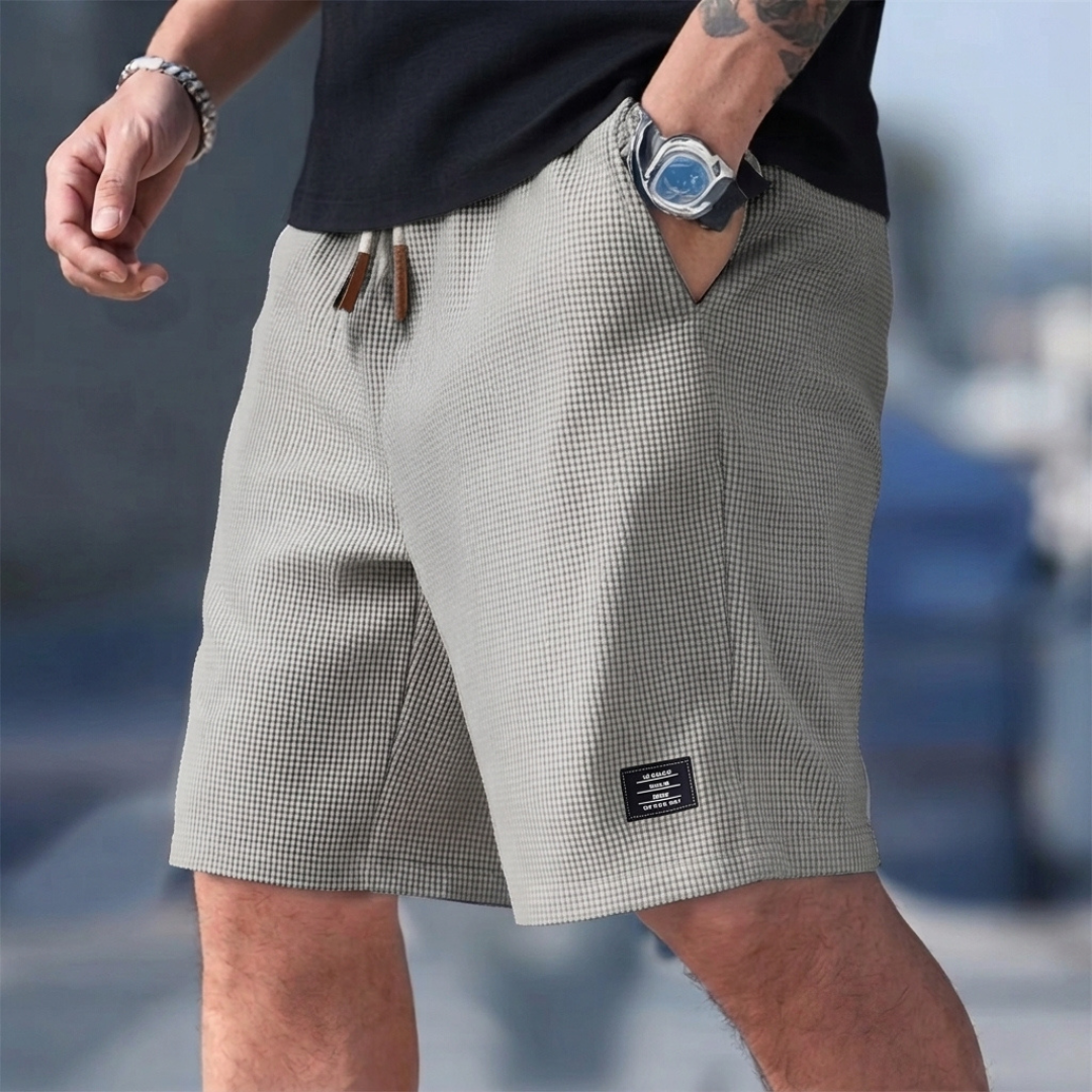 Short homme casual gris porté, taille élastique et poche latérale