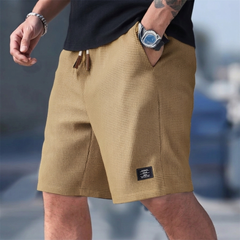 Short homme casual kaki porté avec cordon de serrage et étiquette latérale