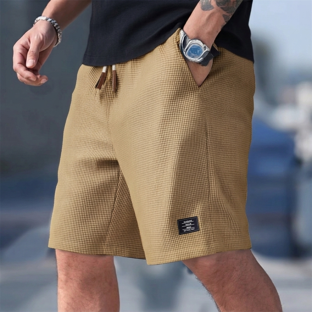 Short homme casual kaki porté avec cordon de serrage et étiquette latérale