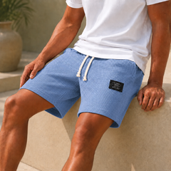 Short homme gaufré bleu clair porté assis avec cordon de serrage noué