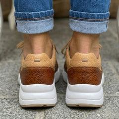 Sneakers femme imprimé animal posées sur fond neutre, vue légèrement plongeante