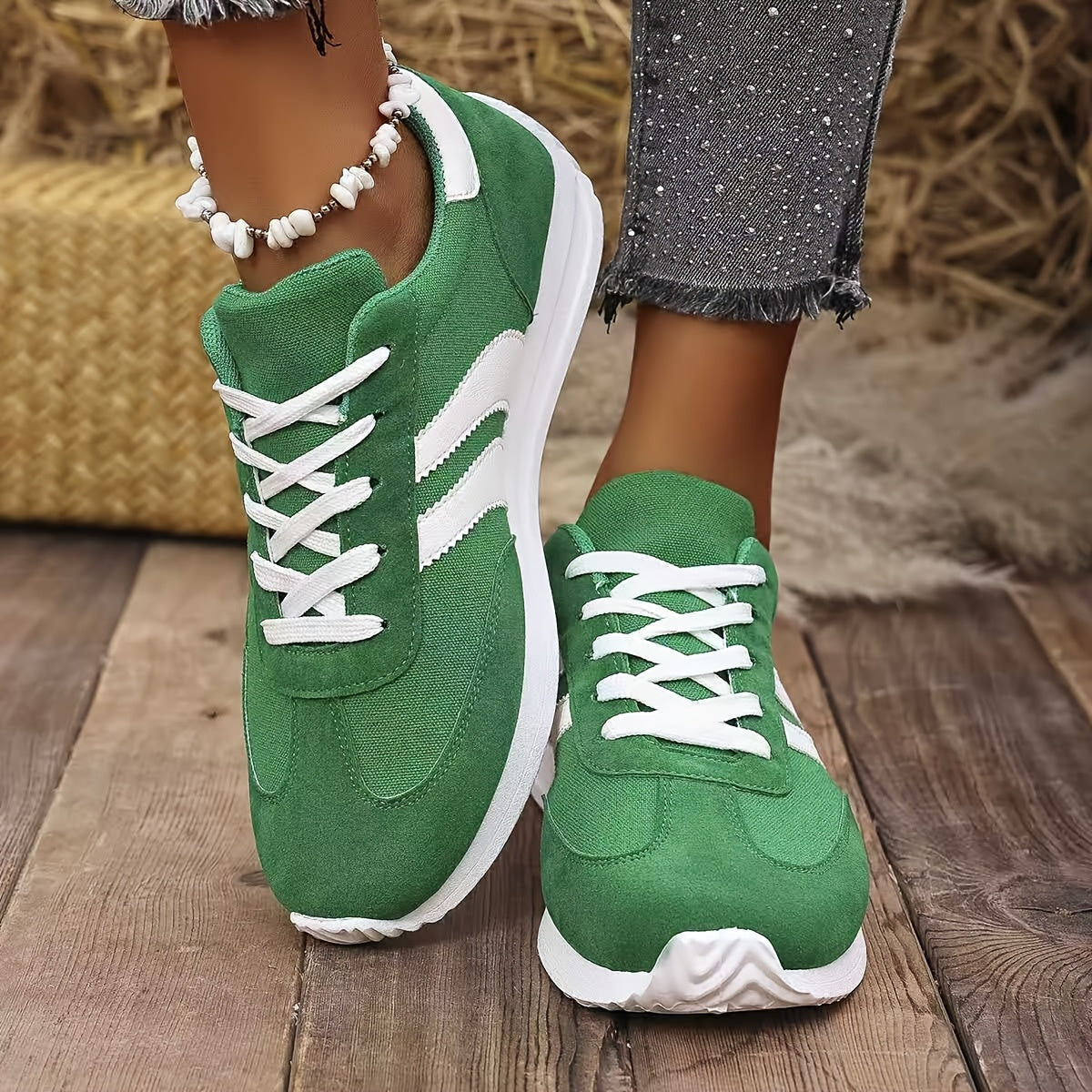 Sneakers femme vertes à lacets blancs portées avec un jean gris