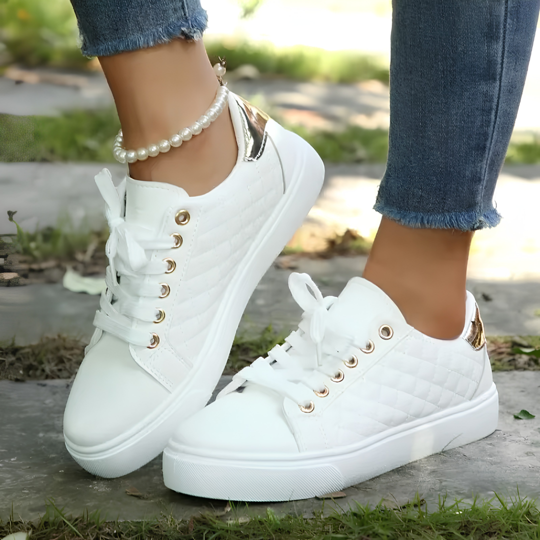 Vue de dos des sneakers blanches Clarice mettant en valeur le contrefort doré au talon