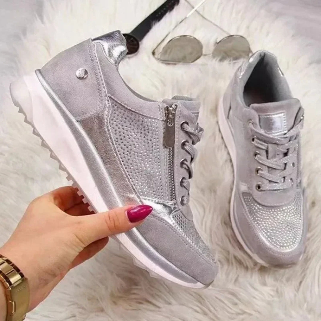 Sneakers doré rosé tenues en main montrant le détail zip et la semelle