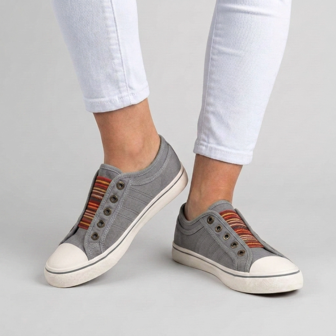 Sneakers grises sans lacets posées à plat, vue de trois quarts