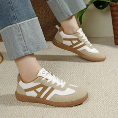Paire de sneakers casual femme beige portée avec un pantalon clair, vue latérale gauche
