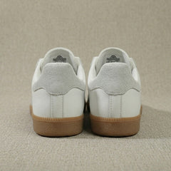 Vue arrière des sneakers femme blanches, détail talon logo et finitions propres