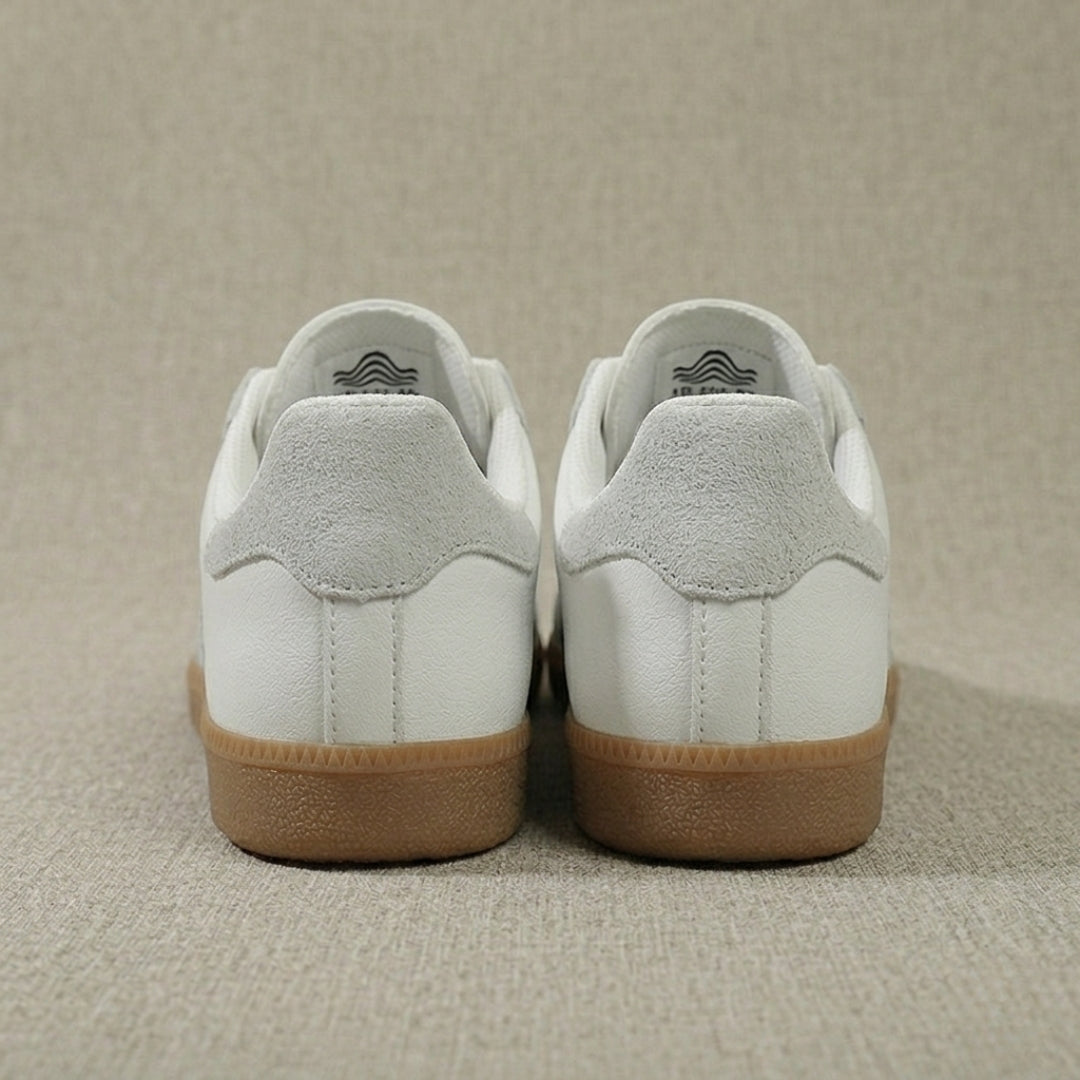 Vue arrière des sneakers femme blanches, détail talon logo et finitions propres