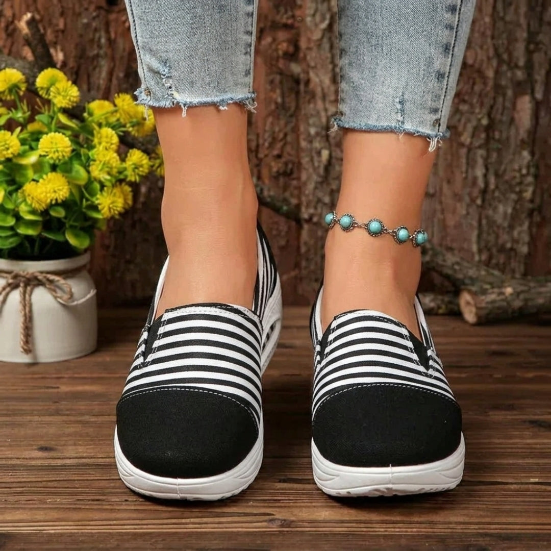 Sneakers femme slip-on rayées noir et blanc portées avec jean