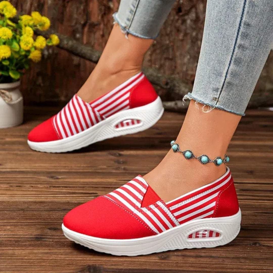 Vue de côté chaussure slip-on rouge à rayures blanches sur semelle plateforme