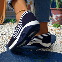 Sneakers bleu marine rayées avec semelle antidérapante inclinée montrant la bulle d'air
