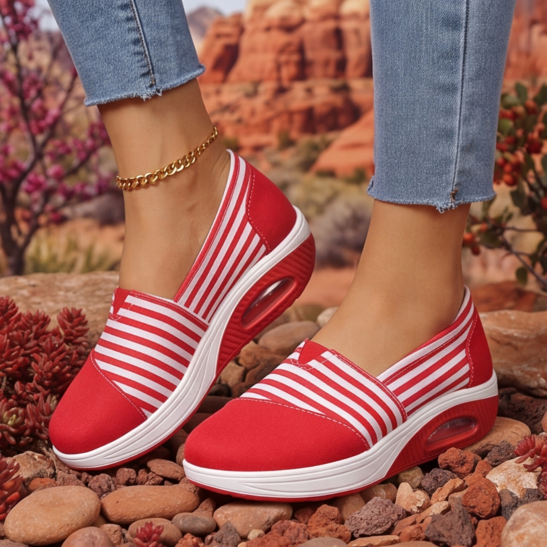 Sneakers rouges rayées de profil avec bulle d'air visible dans la semelle