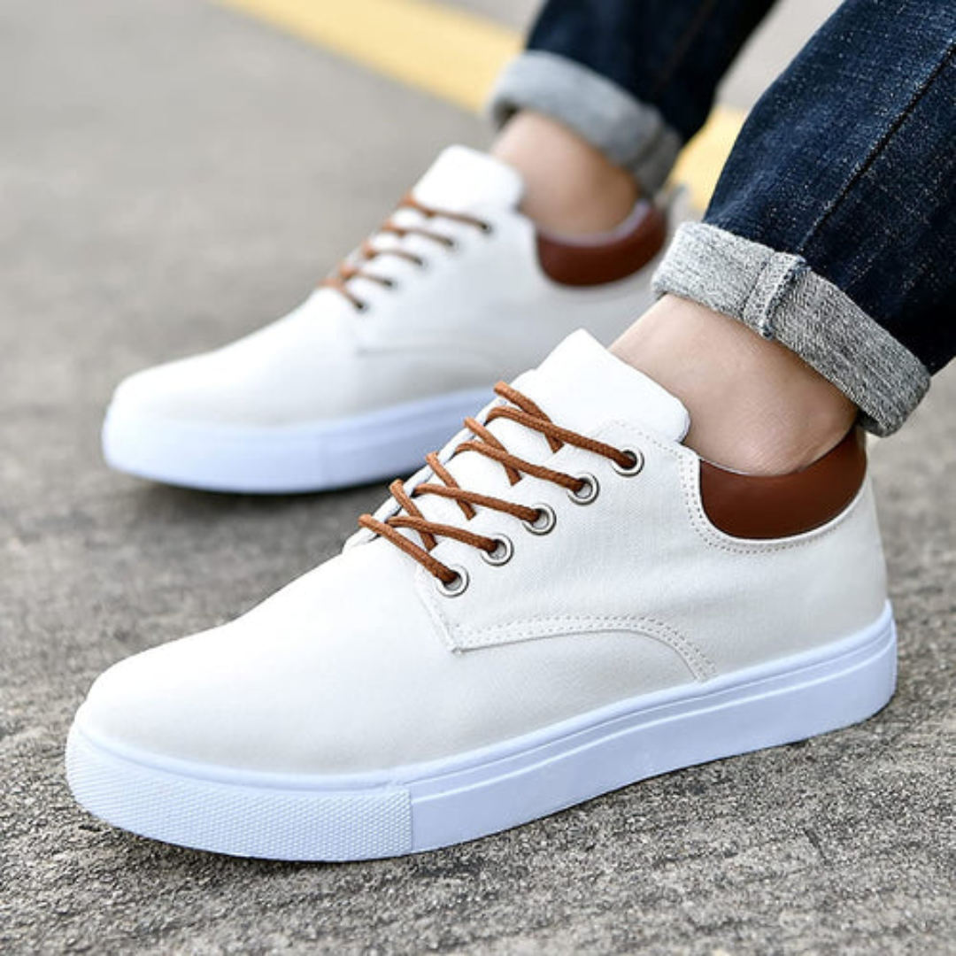 Paire de sneakers blancs vue du dessus sur sol béton
