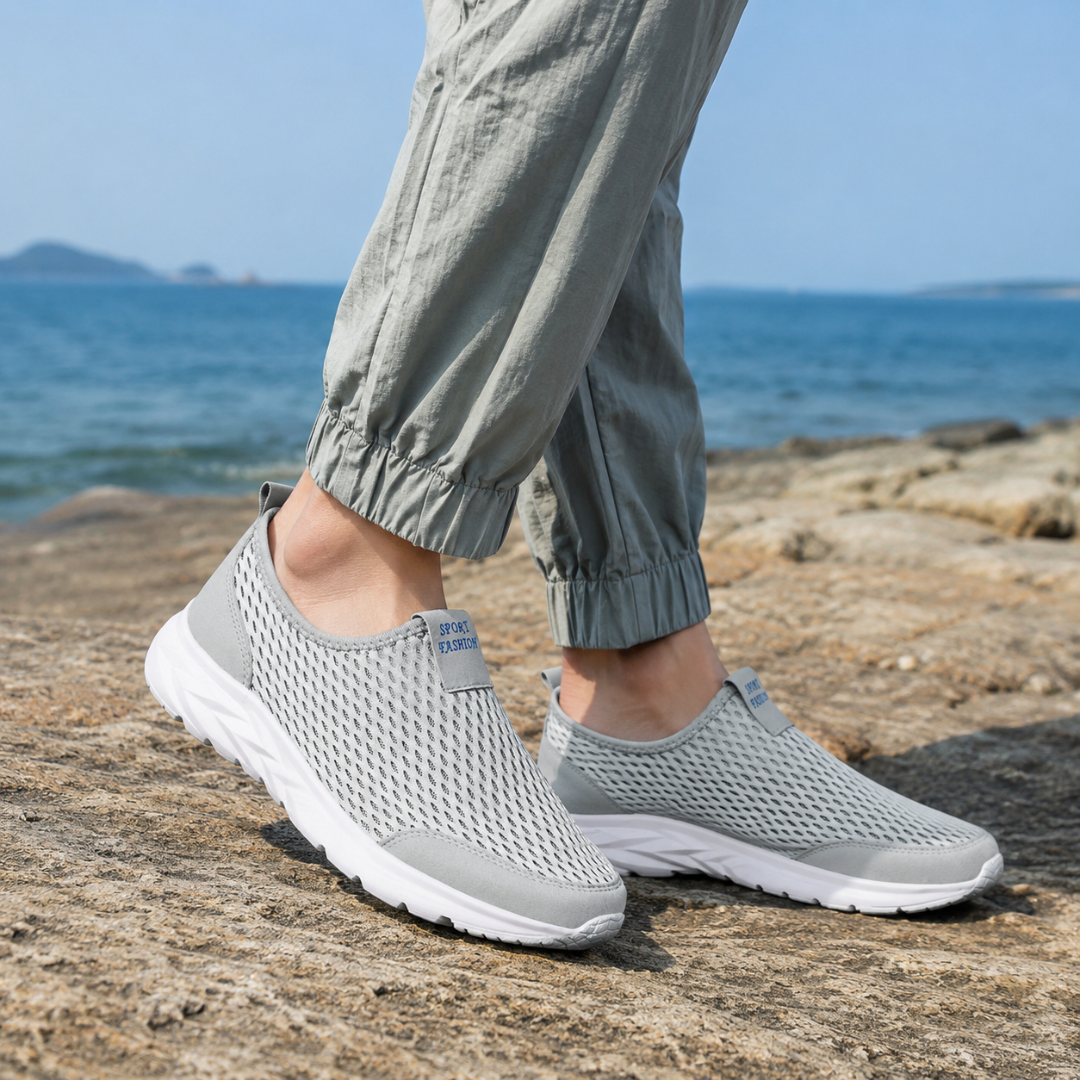 Sneakers gris sans lacets portées avec un pantalon gris clair, vue de profil