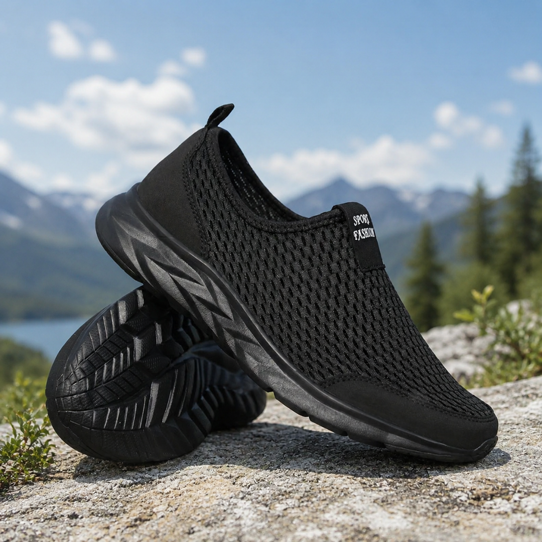 Sneakers noires sans lacets en mesh, vue de profil sur fond naturel