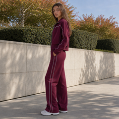 Ensemble rouge vu de profil, veste zippée courte et pantalon à liseré latéral
