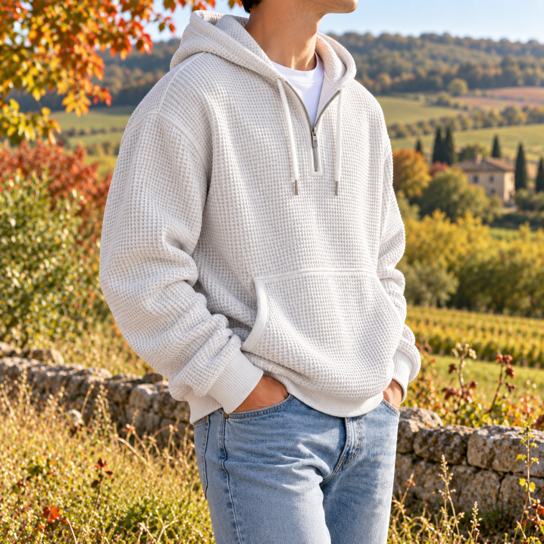 Sweat à capuche blanc homme porté avec un pantalon clair, fermeture demi-zip visible