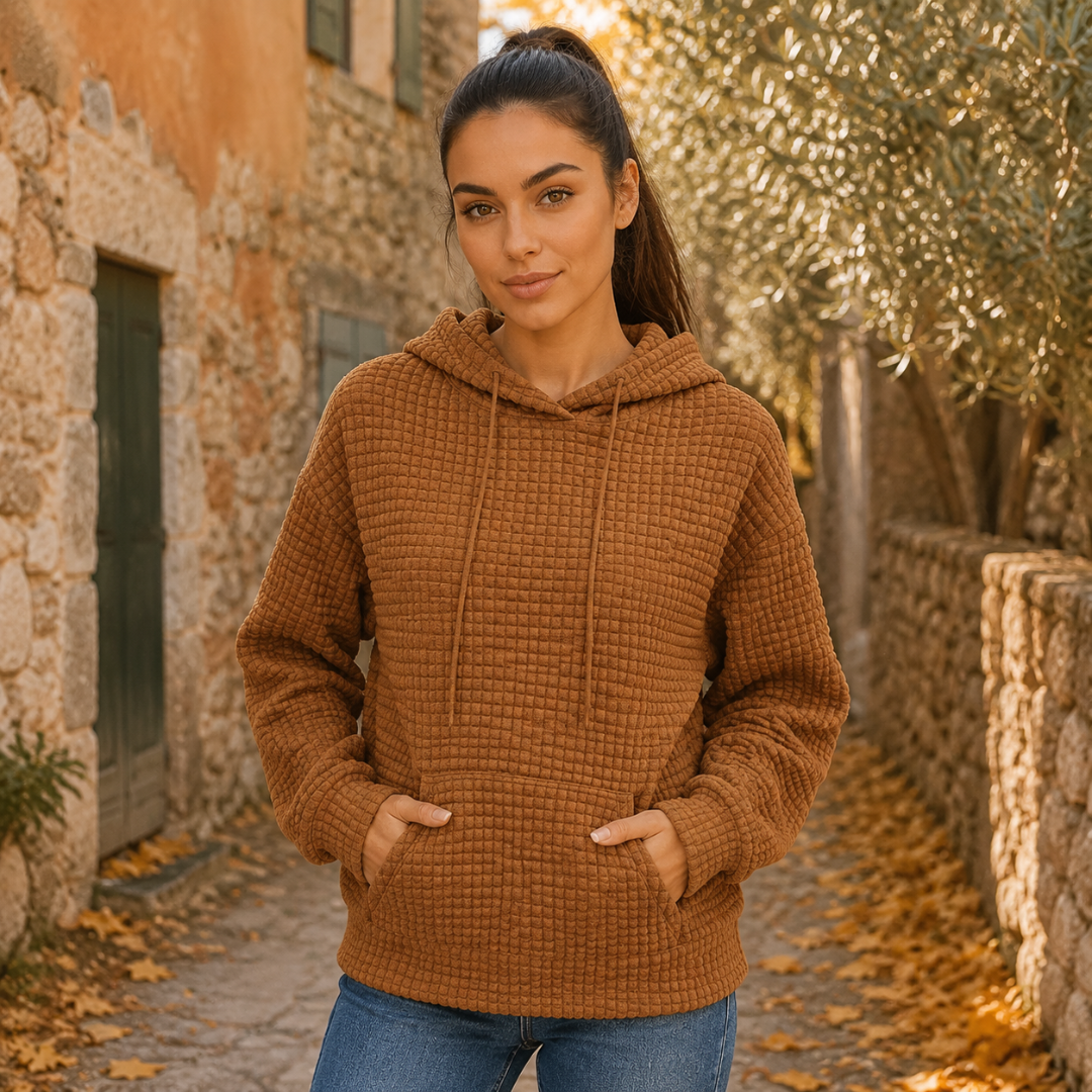 Sweat à capuche marron gaufré, mains glissées dans la grande poche kangourou