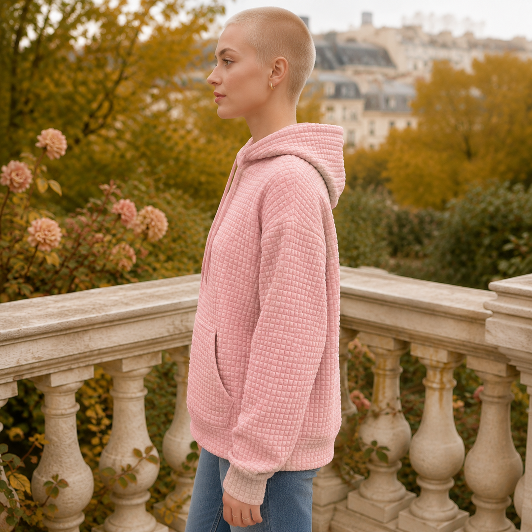 Vue de profil du sweat à capuche rose, poignets en bords-côtes et texture gaufrée