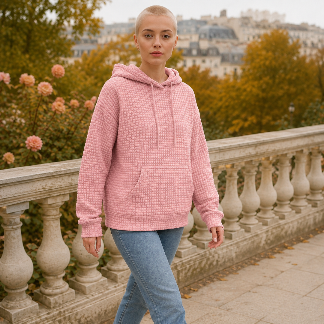 Femme en marche portant le sweat à capuche rose gaufré avec grande poche devant