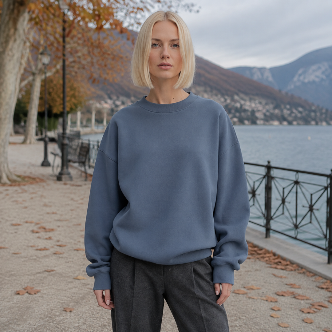 Sweat femme bleu à col rond côtelé, épaules descendues, avec pantalon gris