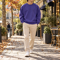 Homme en marche portant un sweat violet à col rond et pantalon clair