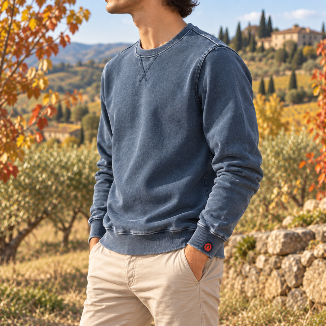 Sweat homme bleu délavé de profil, petite étiquette rouge sur le bas de manche