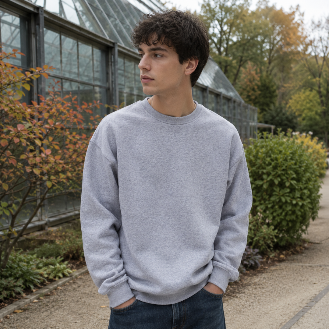 Sweat homme gris clair chiné à col rond côtelé porté avec un pantalon foncé