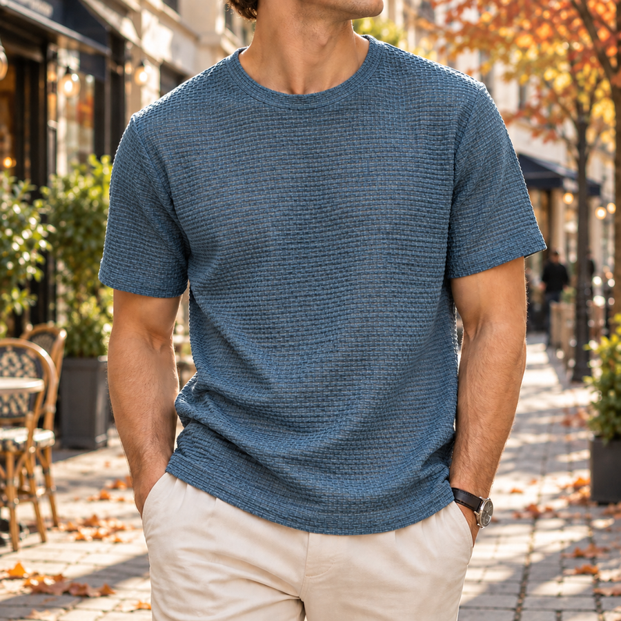 T-shirt homme bleu à col rond, maille texturée, porté avec un pantalon beige