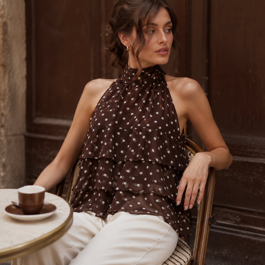 Top marron à pois blancs assis à une table de café