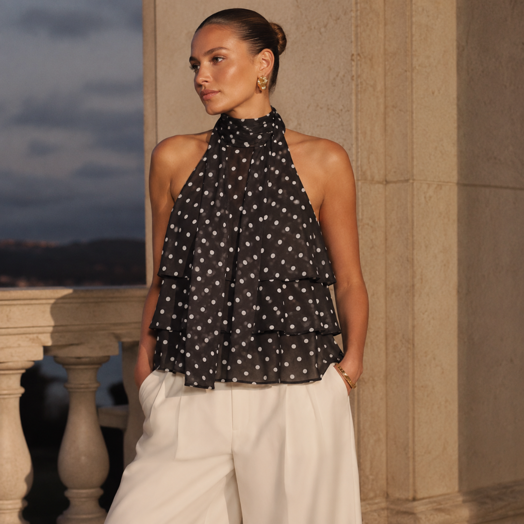 Top noir à pois blancs avec volants superposés au coucher du soleil