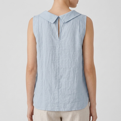 Top femme col bénitier bleu clair porté avec un pantalon beige, vue rapprochée