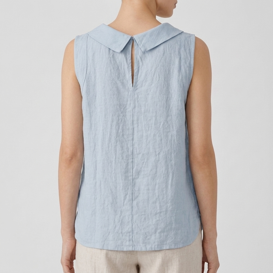 Top femme col bénitier bleu clair porté avec un pantalon beige, vue rapprochée