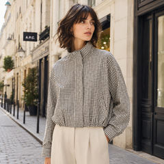 Veste à carreaux noir et blanc fermée jusqu'au col, portée sur pantalon clair en rue