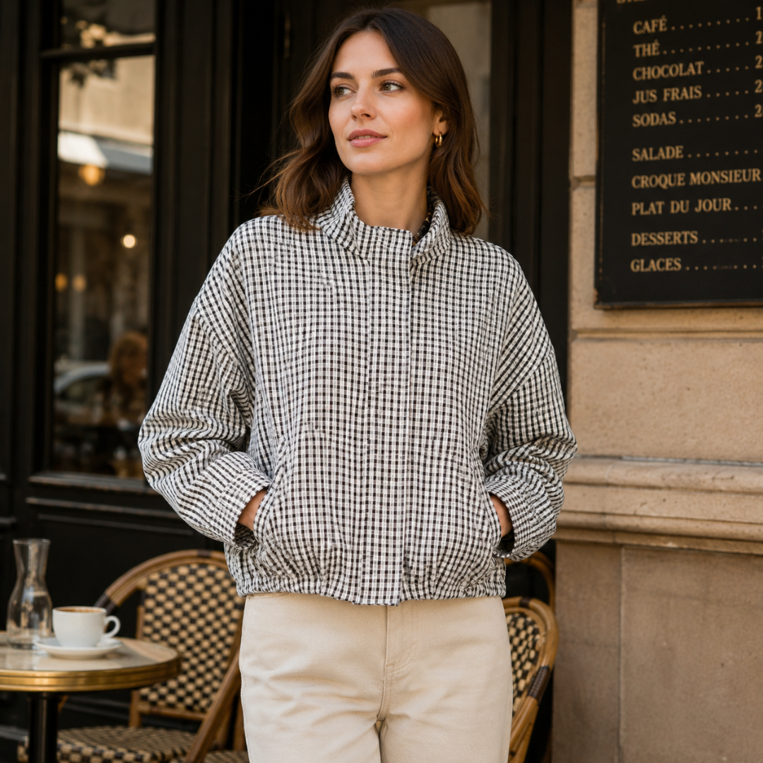 Bomber court à carreaux noir et blanc avec mains glissées dans les poches latérales