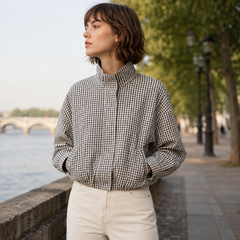 Veste bomber courte à carreaux noir et blanc portée col montant fermé au bord de l'eau