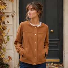Veste femme marron fermée devant une porte noire, col rond et boutons dorés