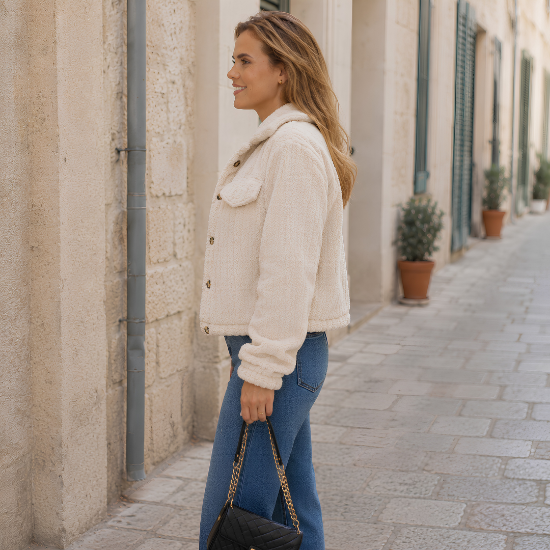 Veste beige de côté, col rabattu et ligne courte sur pantalon bleu