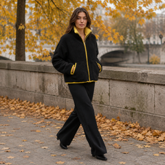 Veste noire zippée en marche, col relevé jaune et poches passepoilées contrastées