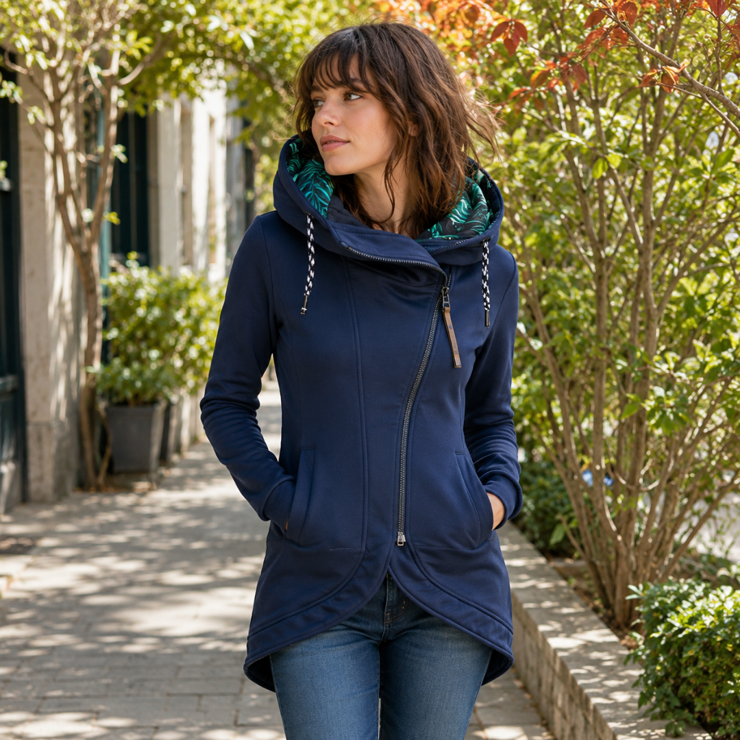 Veste bleue à capuche fermée par un zip asymétrique, deux poches passepoilées