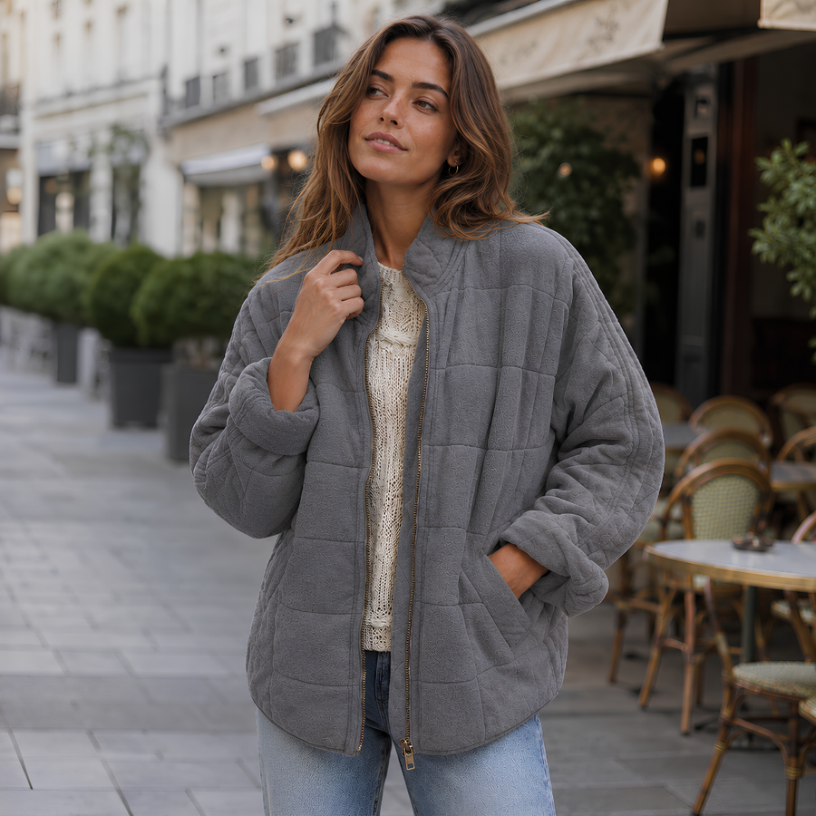 Veste matelassée gris foncé à col montant et fermeture zippée dorée ouverte