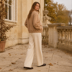 Veste beige vue de trois quarts dos, manches longues et volume généreux