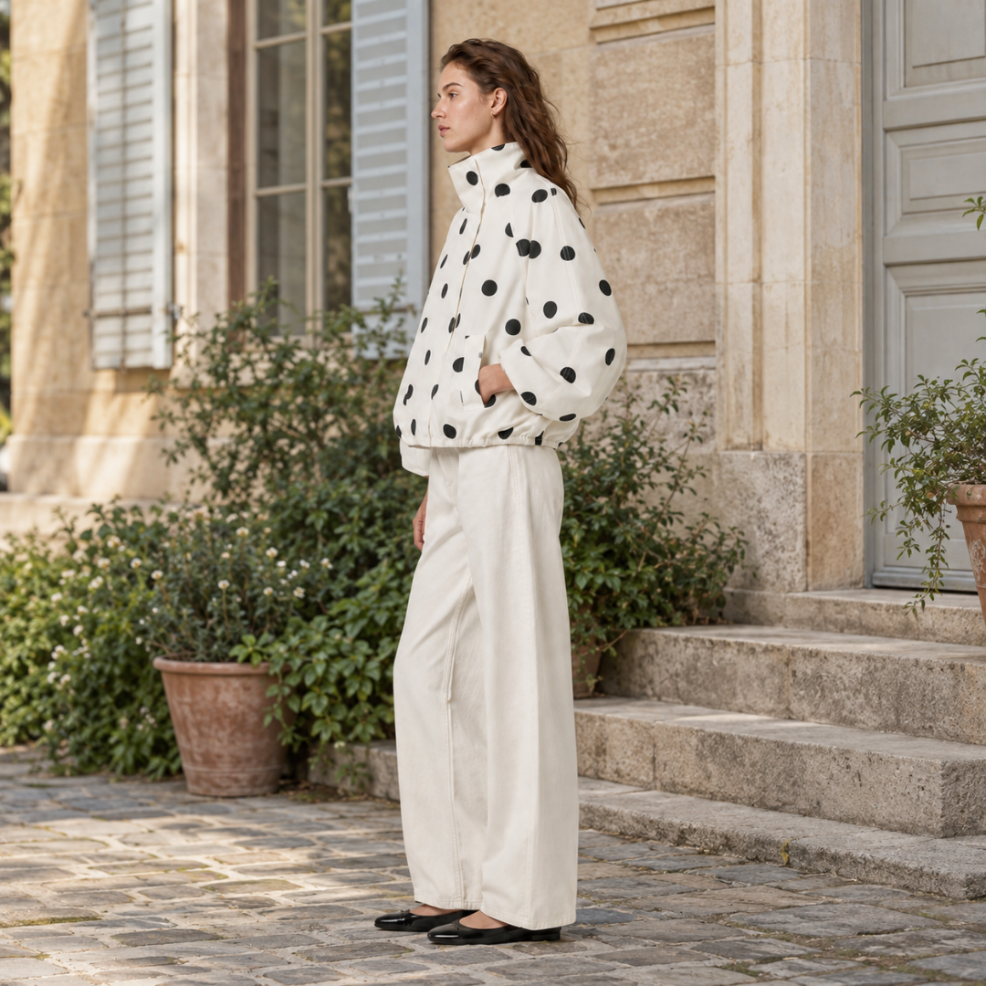 Profil de la veste à pois, col montant haut et volume blousant sur les manches